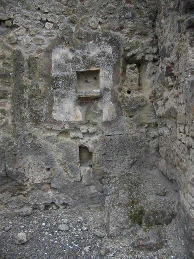 IX.7.21/22 Pompeii. May 2003. Hearth in north-west corner of atrium of IX.7.21. 
Above the hearth in the west wall is a panel of white stucco. In the panel is a square niche.
Photo courtesy of Nicolas Monteix.
