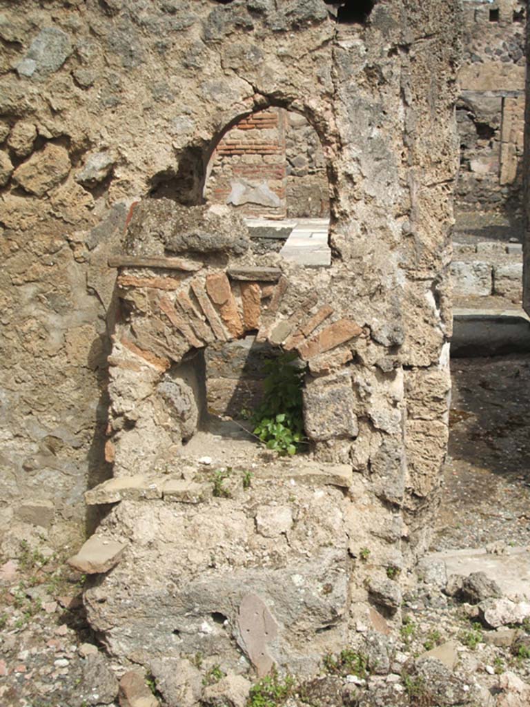 IX.7.25 Pompeii. May 2005. Looking north into IX.7.24, from north-west corner of atrium “2”.
Remains of hearth in atrium, below the fallen rear of arched niche, as described by Boyce (see IX.7.24).
