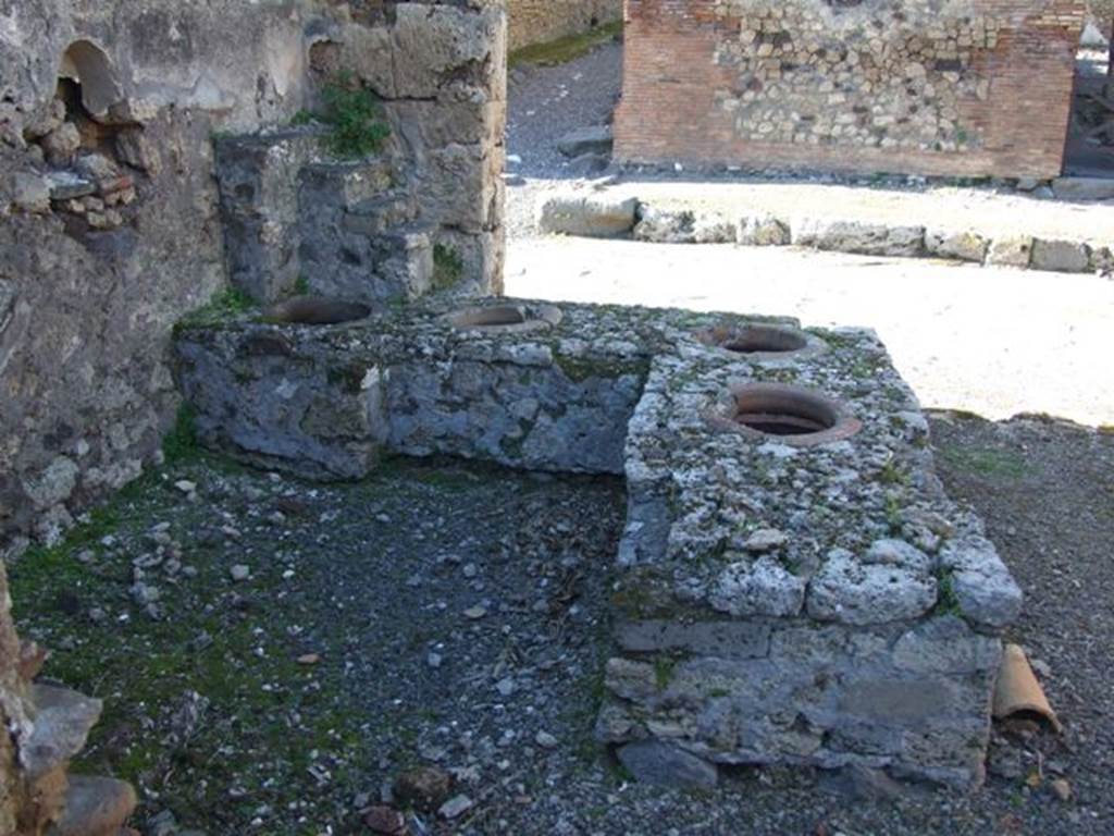 IX.9.1 Pompeii.  March 2009. Looking north at counter with 4 dolia, niche and display shelving.