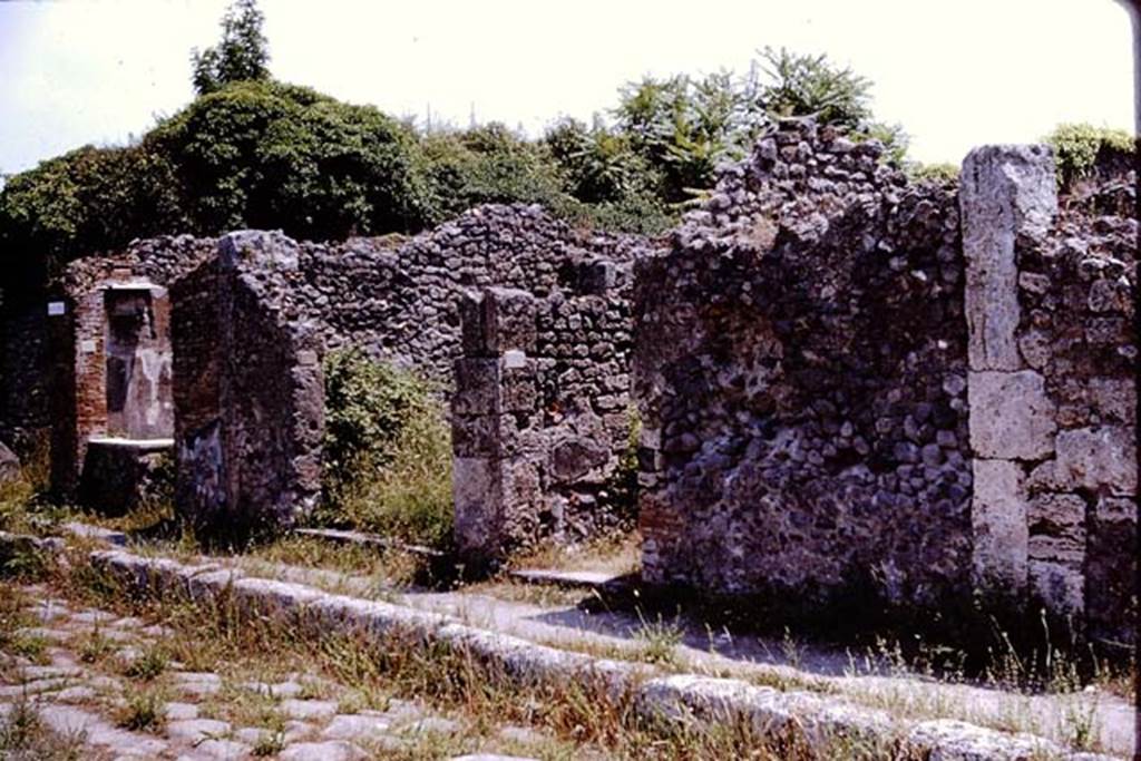 IX.9.7, central doorway, Pompeii. 1964. Looking towards doorways on east side of insula 9, on south side of  Via di Nola.  Photo by Stanley A. Jashemski.
Source: The Wilhelmina and Stanley A. Jashemski archive in the University of Maryland Library, Special Collections (See collection page) and made available under the Creative Commons Attribution-Non Commercial License v.4. See Licence and use details.
J64f2036
