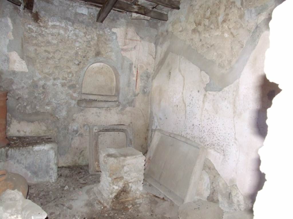 IX.9.10 Pompeii.  March 2009.  East wall with Niche, and in front of it a masonry altar.  The niche was surrounded by a rectangular panel of white stucco marked of by red and black stripes.  Above the niche was a painted double garland suspended from painted nails.