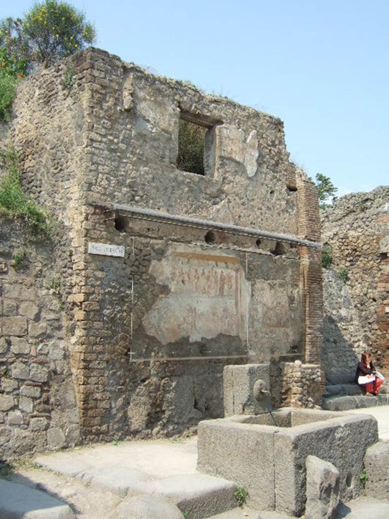 IX.11.1 Pompeii. May 2006. Front façade of house on west side of entrance doorway, with steps. House with street shrine and fountain outside.
