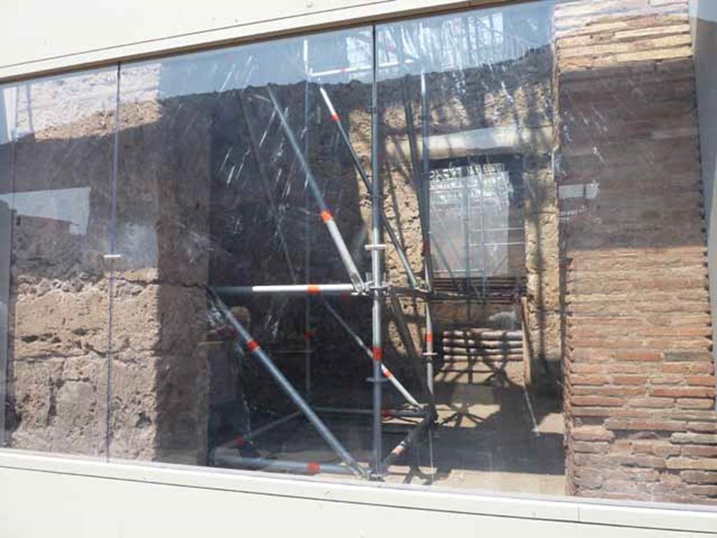 IX.12.3 Pompeii. May 2010. Entrance behind glass front. According to Spinazzola, 
“On either side of entrance IX.12.4 there were two workshops with large doorways but there was no clue as to the industry carried out in these shops. The one at IX.12.3 was more modest than IX.12.5, and led into the atrium of IX.12.4, and with very narrow stairway against the left (west) wall, for the exclusive use of the atrium to the upper floor: the other one at IX.12.5  was over 5metres wide with a rear room, and completely detached from the rest of the house without any communication or doorway.”
Spinazzola, V. Pompei, alla luce degli Scavi Nuovi di Via dell’Abbondanza (Anni 1910-1923), Vol.2, p.716.

