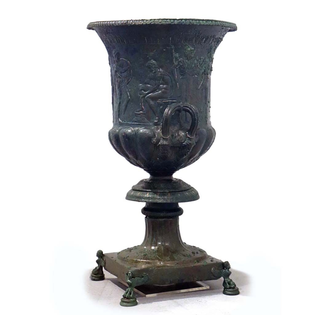 IX.13.1-3 Pompeii. February 2021. 
Side and rear of bronze krater with scenes in relief, found in triclinium, on display in Antiquarium, VIII.1.4.

