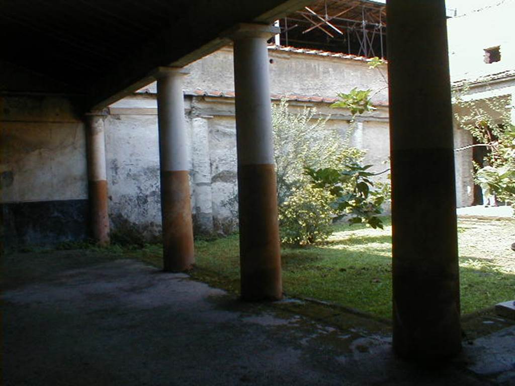 IX.13.1-3 Pompeii. September 2004. Room 9, looking west along south portico.
