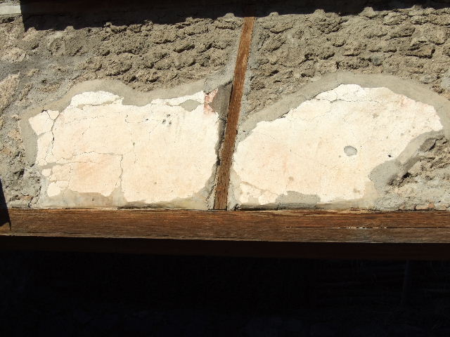 IX.13.6 Pompeii. December 2005. Remains of painted plaster above entrance.