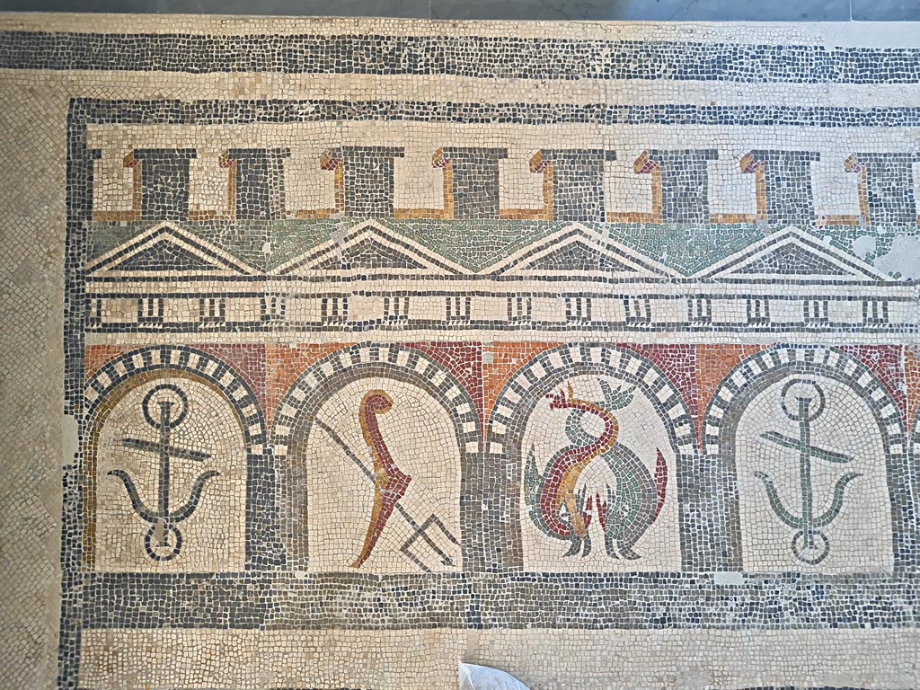 Villa of Diomedes ? or VI 17.10 Pompeii ?. June 2024.  
Detail from mosaic of “doors”, starting with an anchor, trident, two dolphins, an anchor, one dolphin, and a stern of a ship with rudder. 
On display in Naples Archaeological Museum, Room CXXXIV.  Photo courtesy of Giuseppe Ciaramella. 
