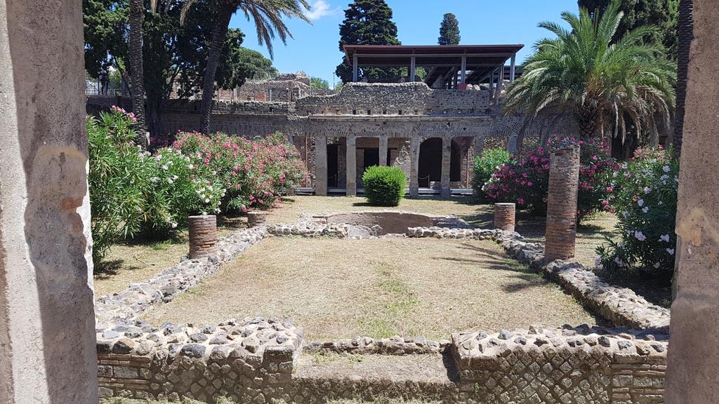 HGW24 Pompeii. Villa of Diomedes. August 2023. 
Looking east over garden across pergola supported by six columns towards pool. Photo courtesy of Maribel Velasco.
