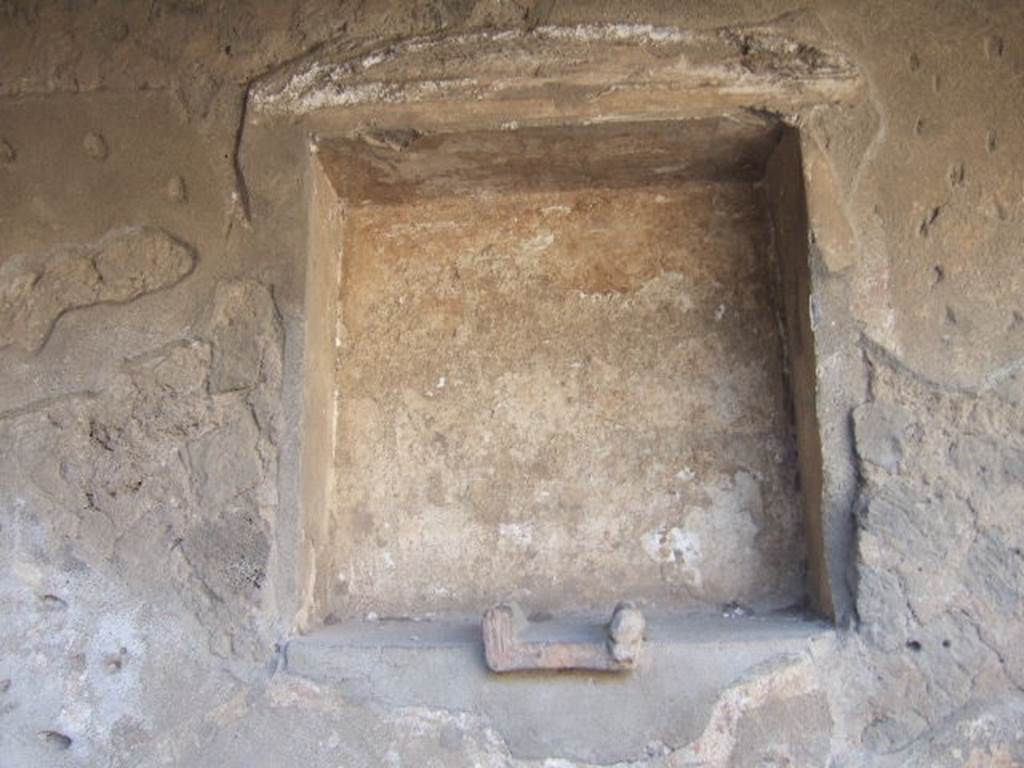 Villa of Mysteries, Pompeii. May 2006. Room 61, niche in north wall, with remains of stucco pediment above. According to Boyce, the small altar embedded in the floor of the niche, was decorated with an image of a gorgon and two heads of bulls. Two sculptured heads, a terracotta one of a goddess and another of tufa representing Hercules, were found inside the niche. See Boyce G. K., 1937. Corpus of the Lararia of Pompeii. Rome: MAAR 14. (p.97) 