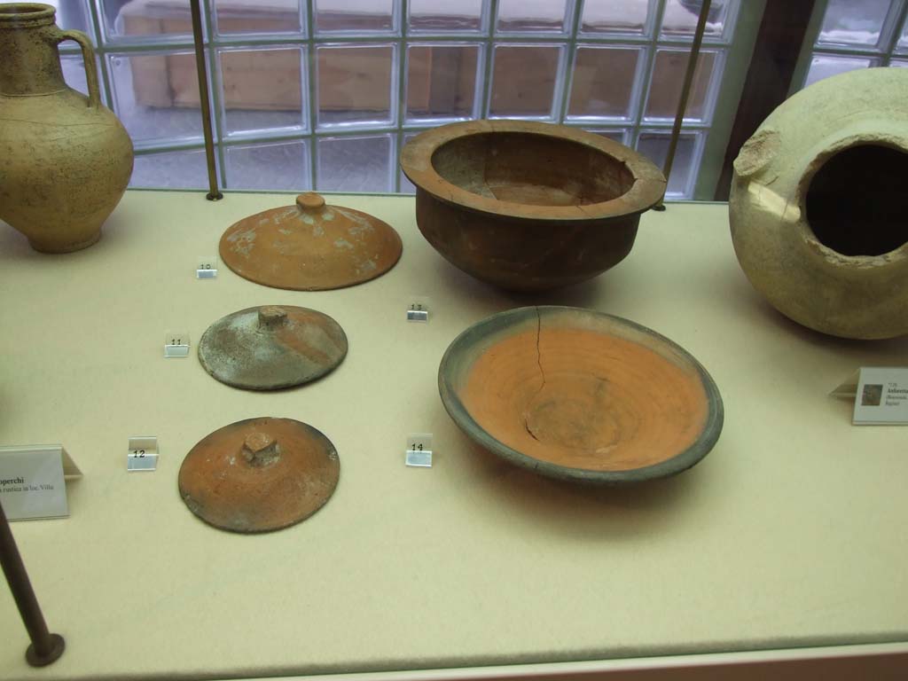 Finds from Villa Regina Boscoreale. December 2006. Now in Boscoreale Antiquarium.
Left are Terracotta covers from storeroom XII. 
Right front is a ceramic plate with black rim from room II. 
Behind is a terracotta cooking pot (pentola) from room II.
