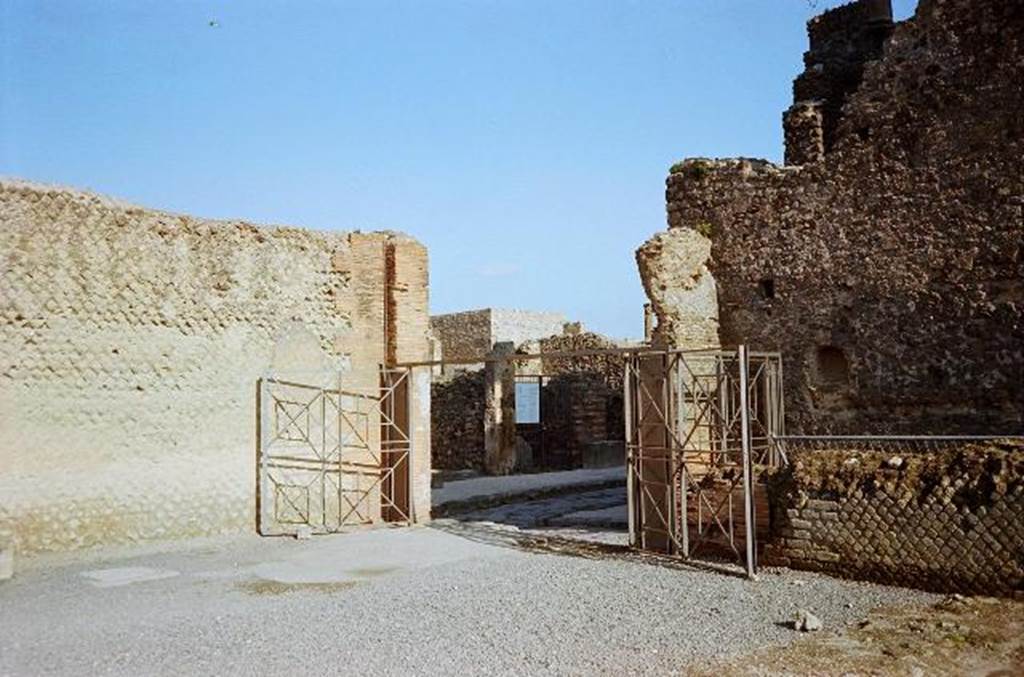 Via Marina, looking north through gates of Temple of Venus towards VII.7. January 2010.
The unnamed vicolo between VIII.1.3 and VIII.1.1 (alleyway) between the Basilica and Temple of Venus is on the right of the picture.
Photo courtesy of Rick Bauer.   

