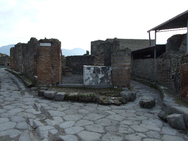 Via Consolare, December 2018. 
Looking south to entrance doorway of VI.4.1, on junction of Via Consolare, on left, with Vicolo del Farmacista, on right. 
Photo courtesy of Aude Durand.

