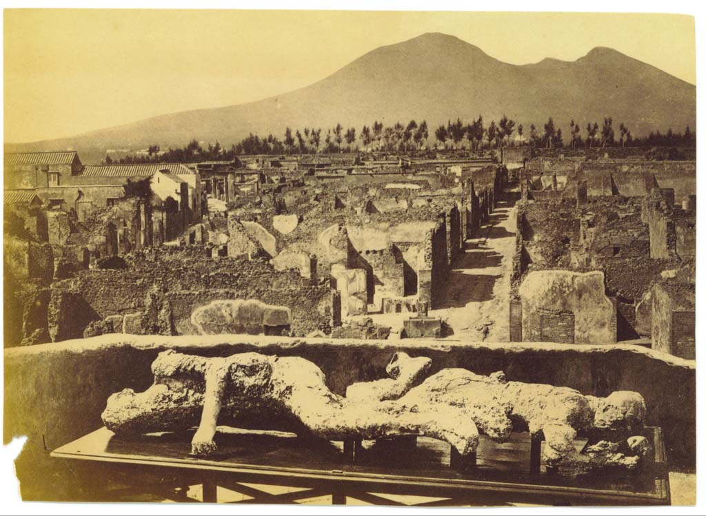 Via Consolare, on the left, undated photograph but after 1863, as the plaster-casts of victims numbered 2 and 3 were found in 1863. 
Photographed taken on an upper floor (possibly from VII.6.7), looking north towards Via Consolare, Vicolo di Modesto and Vesuvius.
Photo courtesy of Eugene Dwyer.
