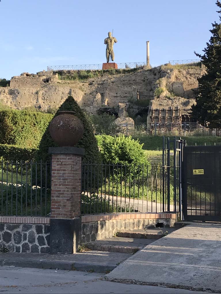 Piazza Porta Marina Inferiore. April 2019. Gate to ticket office, on right.
At the top of the escarpment is the Temple of Venus, with one of the giant figures.
Photo courtesy of Rick Bauer.
