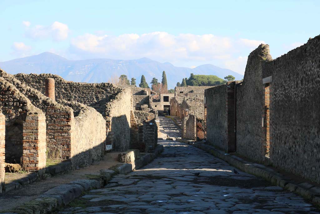 Via del Tempio d’Iside, Pompeii. December 2018. 
Looking east between VIII.4, on left, and VIII.7, on right, towards junction with Via Stabiana, and across into Vicolo del Menander. 
Photo courtesy of Aude Durand.
