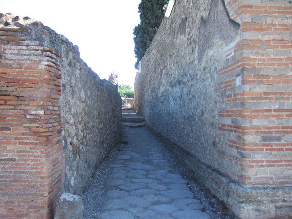 Alleyway leading to steps to the summa cavea (upper area) of Large Theatre. Looking south at VIII.7.27 on Via del Tempio d’Iside. September 2005.  

