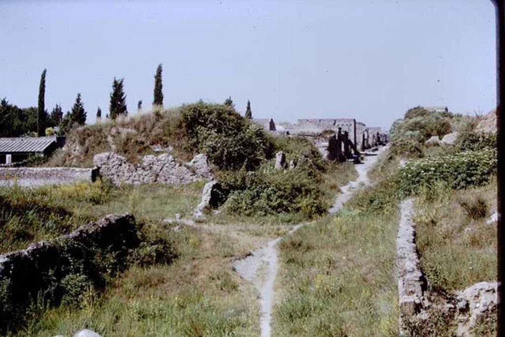 Via dell’Abbondanza, Pompeii. 1976. Looking west along Via dell’Abbondanza from III.7. 
The ramp was built as the only way up and over into the walled site. 
Photo by Stanley A. Jashemski.   
Source: The Wilhelmina and Stanley A. Jashemski archive in the University of Maryland Library, Special Collections (See collection page) and made available under the Creative Commons Attribution-Non Commercial License v.4. See Licence and use details.
J76f0354

