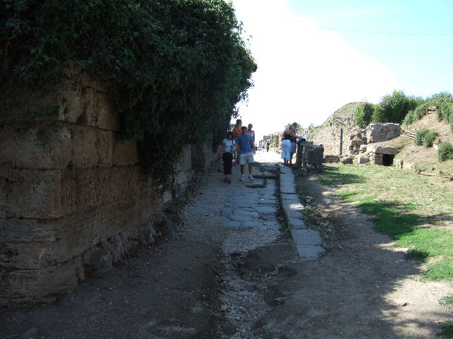 Via dell’Abbondanza. May 2006. Looking south along the city walls at the junction with the Sarno Gate. 
The structure on the left is the modern railway and foot bridge which blocks the ancient route of the Via dell’Abbondanza.
