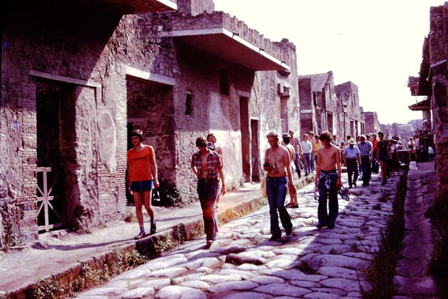 Via dell’ Abbondanza, south side, Pompeii. 1976. Looking west from near I.7.5. Photo by Stanley A. Jashemski.   
Source: The Wilhelmina and Stanley A. Jashemski archive in the University of Maryland Library, Special Collections (See collection page) and made available under the Creative Commons Attribution-Non Commercial License v.4. See Licence and use details. J76f0458
