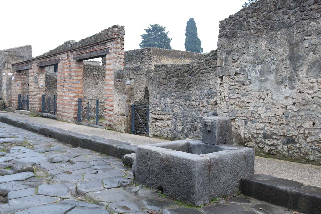 Via dell’Abbondanza, south side. December 2018. 
Looking west from II.1.6 towards II.1.1 at rear of fountain. Photo courtesy of Aude Durand.
