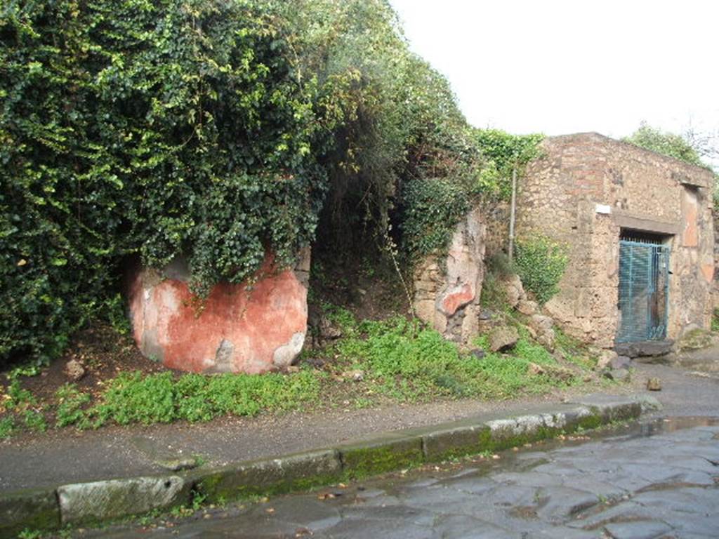 Via dell’Abbondanza, north side. December 2004. III.5.4 on left under bushes, III.5.5 on west corner of junction with unnamed vicolo. 