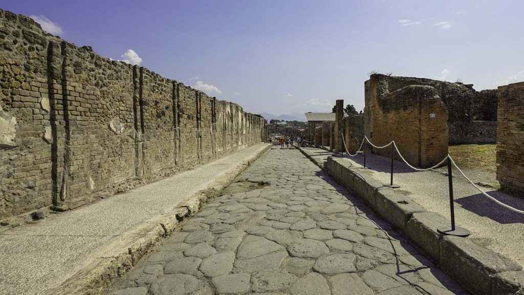 Via dell’Abbondanza, Pompeii. December 2018. 
Looking east between VII.9, on left, and VIII.3.2, on right, with steps in pavement. Photo courtesy of Aude Durand.
