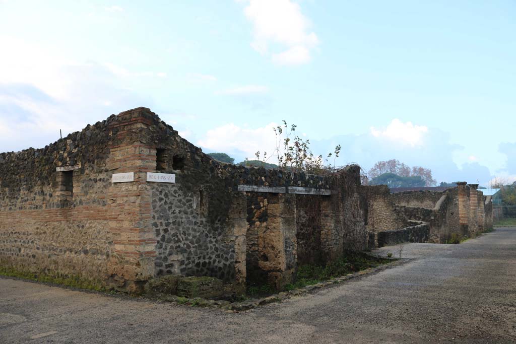 Via della Palestra, south side, Pompeii. December 2018. 
Looking west from junction with Vicolo dei Fuggiaschi, on left, from I.21.5 towards I.21.1, on right. Photo courtesy of Aude Durand.

