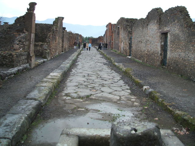 Via delle Scuole between VIII.3 and VIII.2. Looking south from junction with the Forum.  December 2004.