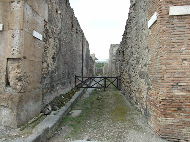 Via di Nola, Pompeii. December 2018. 
Looking north-east to front façade of V.2.1 on east side of junction with Vicolo di Cecilio Giocondo, on left. Photo courtesy of Aude Durand.

