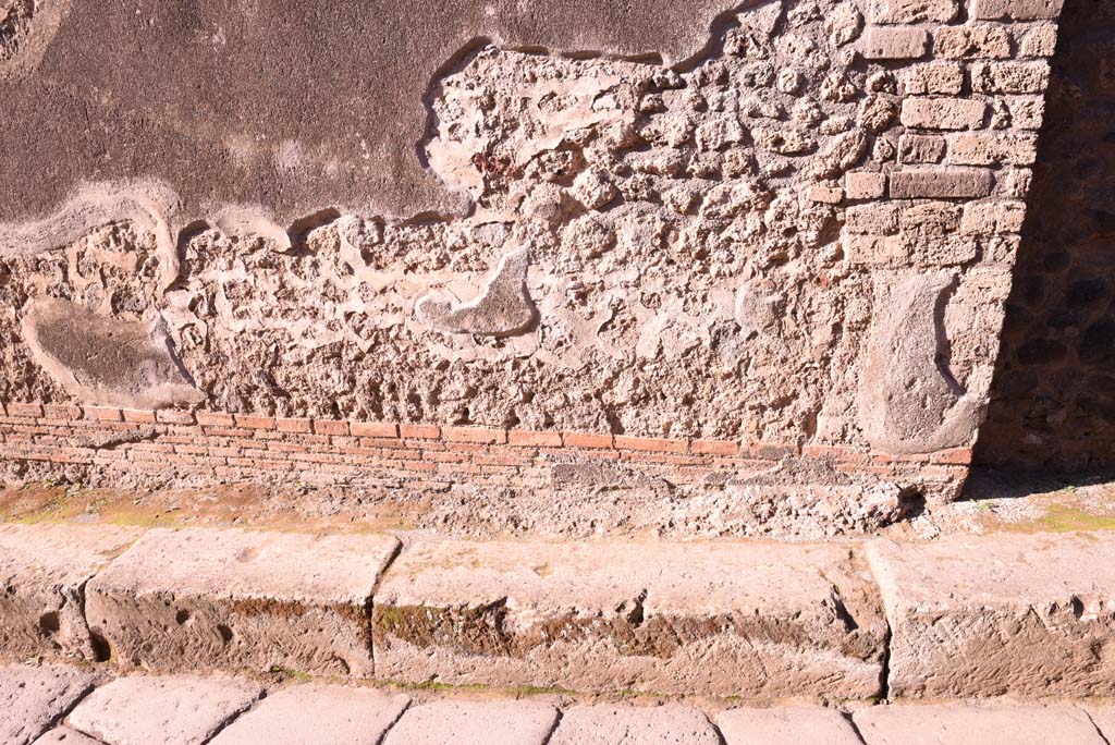Vicolo del Citarista, west side, Pompeii. October 2019. Detail from lower west wall and pavement.     
Foto Tobias Busen, ERC Grant 681269 DÉCOR.
