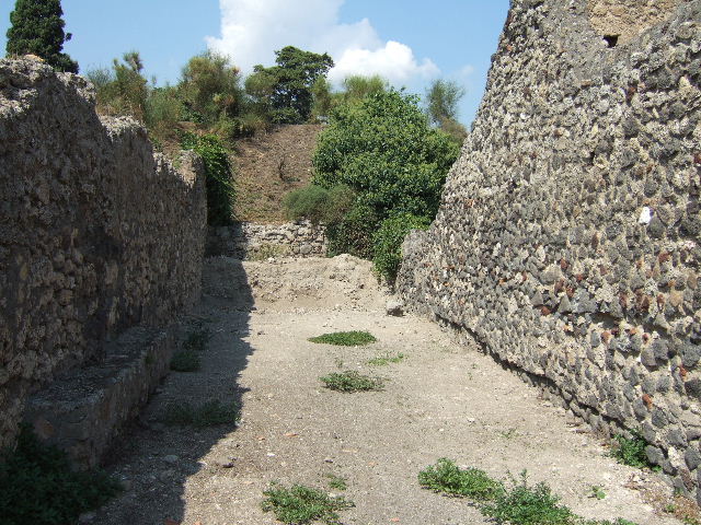 Vicolo della Fullonica between VI.5 and VI.7. Looking north to city walls from VI.5.22. September 2005.
