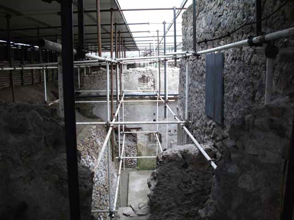 Vicolo di Giulio Polibio, Pompeii. May 2010. Excavation behind IX.13.1.  Looking east from unnamed vicolo.
According to Cerulli Irelli, 
“A work of excavation had been followed to isolate the humidity from the two splendid rear rooms of the said house (i.e. of IX.13.1/3 Julius Polybius), and the rustic quarters of a house has appeared to the north of this last house and presented a small kitchen with cupboard (repositorium) in a notable state of conservation, and a vast lararium picture with several elements on the rear wall of an uncovered/open room: this seemed to be evidence of plebeian art not inferior to the lararium picture found in the actual house of Julius Polybius.”
See Cerulli Irelli, G: Cronache Pompeiane, 2, (II), 1976, Notiziario, attività archeologica. (p.241). 

