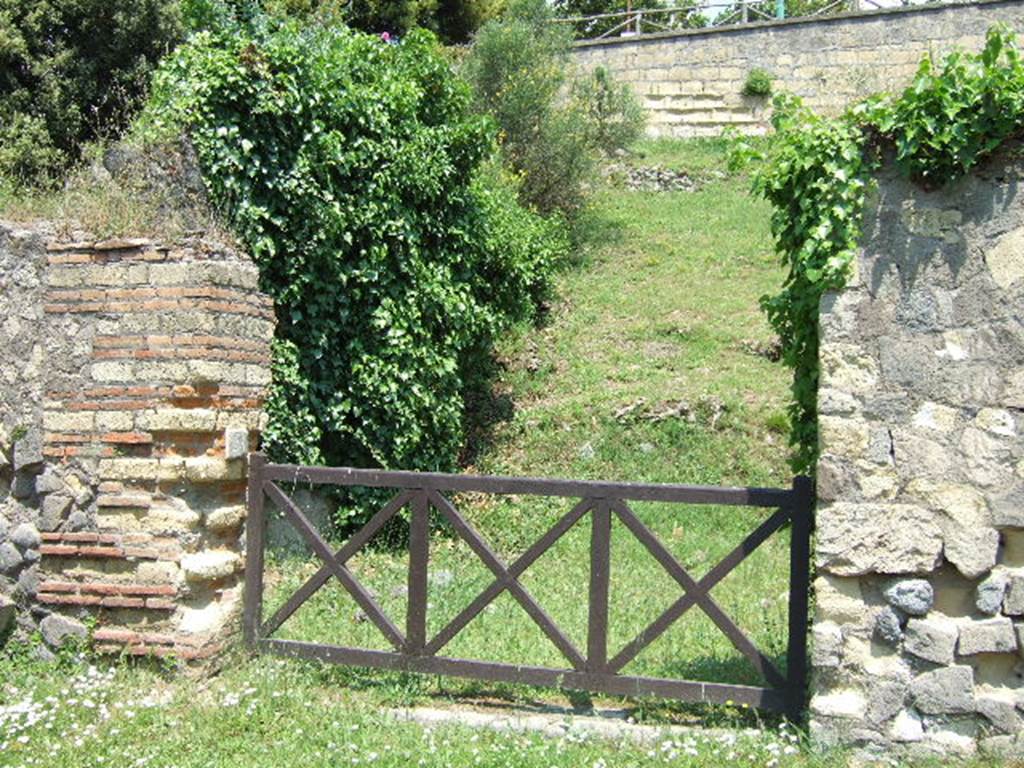 HGE24 Pompeii. May 2006. Looking north-east towards entrance doorway. According to Garcia y Garcia, on 18th September 1943 a bomb smashed the poor remains of the shops at HGE22, 23, 24 and the colonnade outside them. The damage was not recorded in the official report, but can be seen in a photo (fig.398 -Foto SAP neg 57-A) See Garcia y Garcia, L., 2006. Danni di guerra a Pompei. Rome: L’Erma di Bretschneider. (p.163).