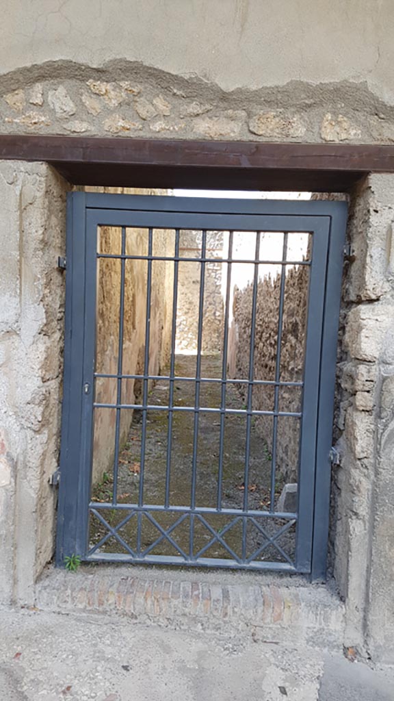 I.10.4 Pompeii. August 2023. 
Entrance doorway to corridor M. Entrance from peristyle to kitchen and garden area.
Photo courtesy of Maribel Velasco.
